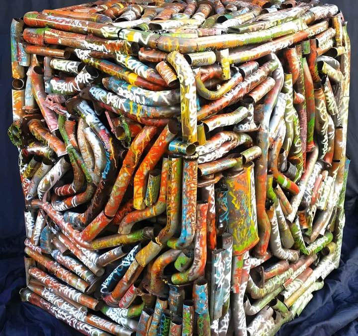 Installation artistique contemporaine de tuyaux métalliques tordus peints dans des couleurs vives Guadeloupe